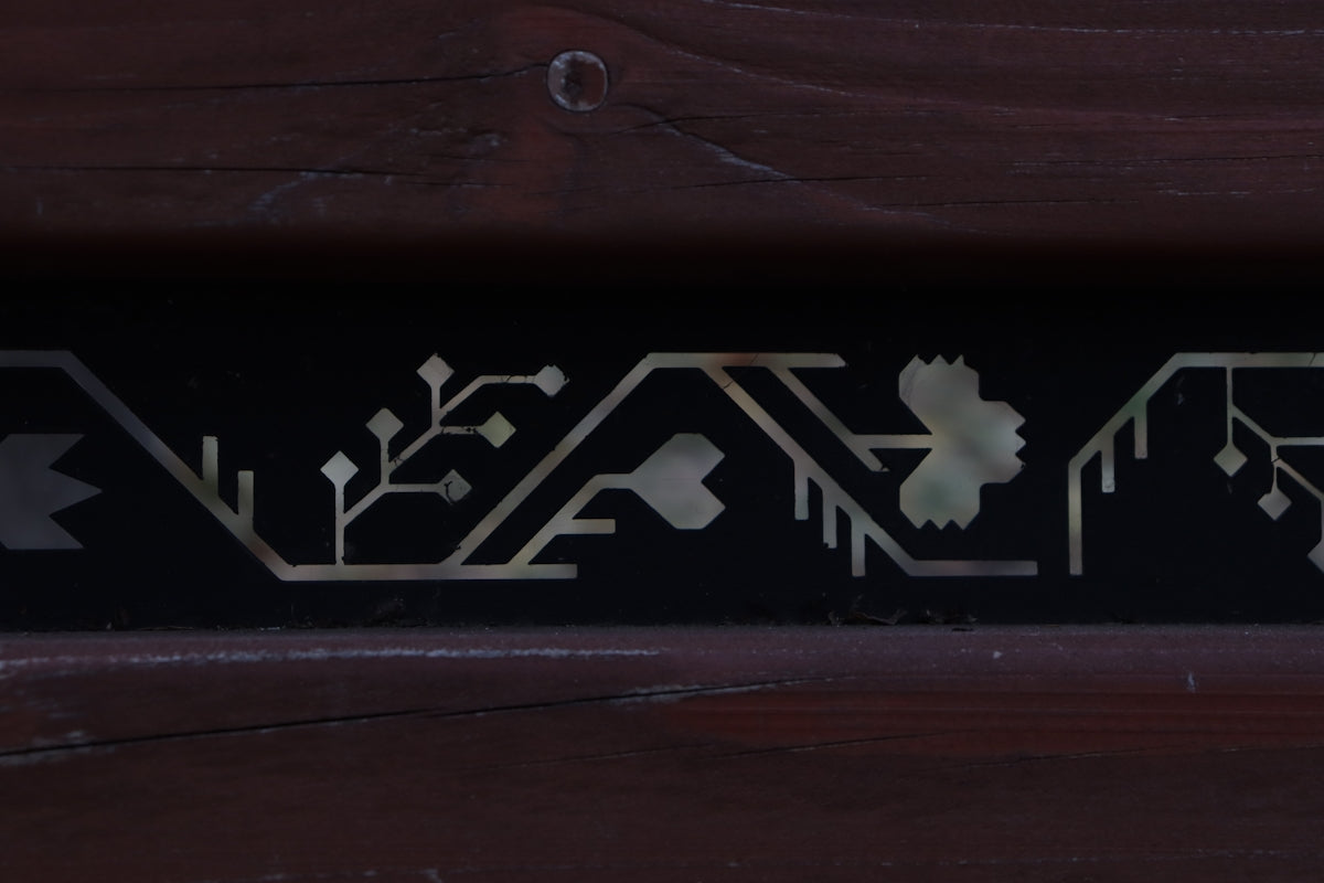 A close up of a wooden bench with metal lettering