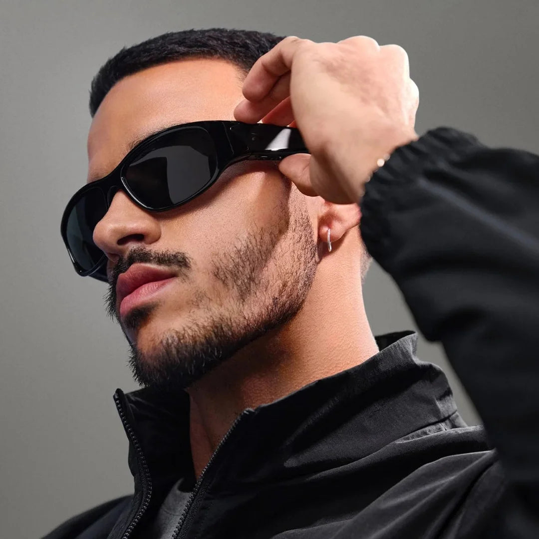 Hombre ajustando gafas Ray-Ban Meta deportivas negras; primer plano mostrando la cámara discreta y el diseño envolvente.