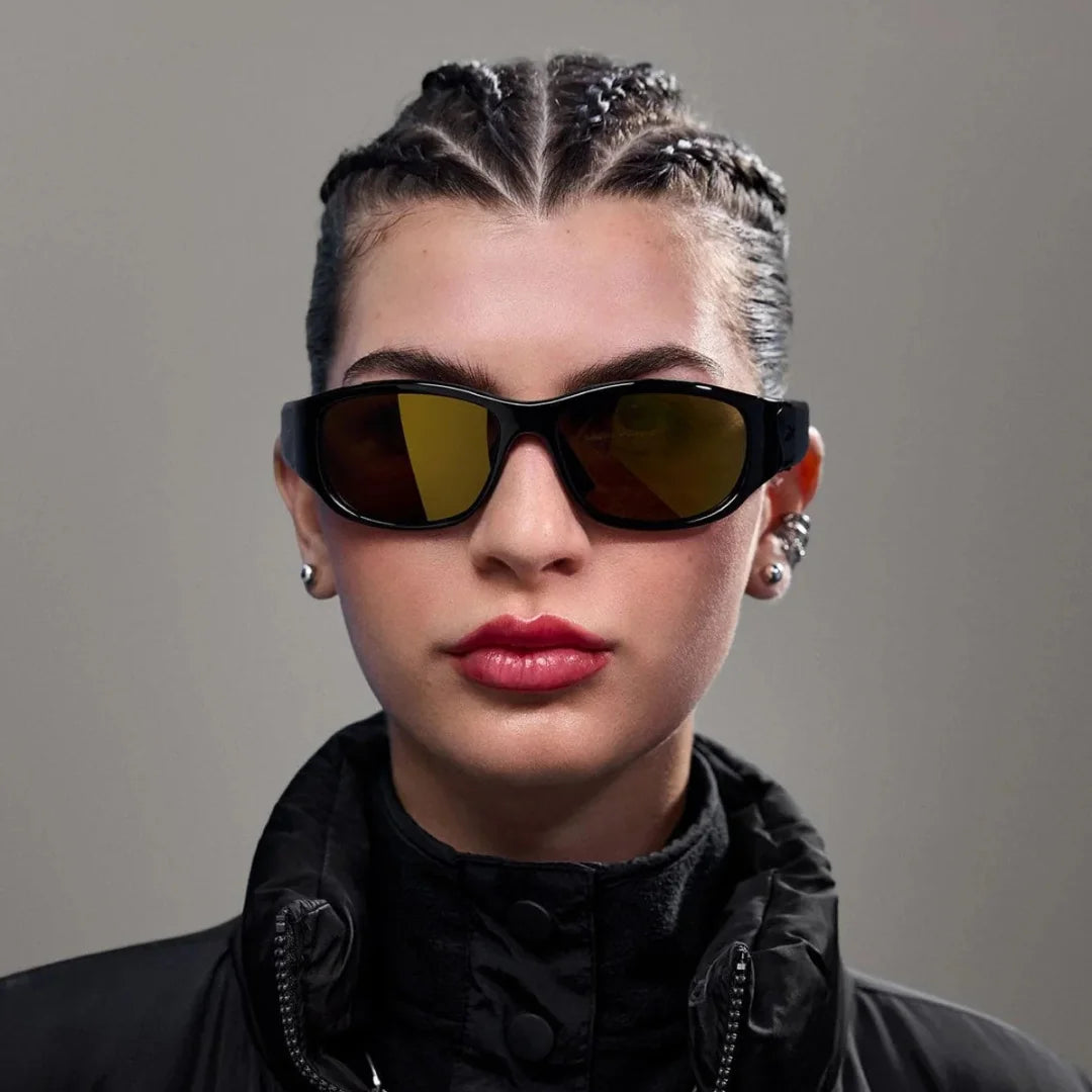 Mujer usando gafas deportivas inteligentes negras con lentes de visión nocturna amarillas, para mejorar el contraste.